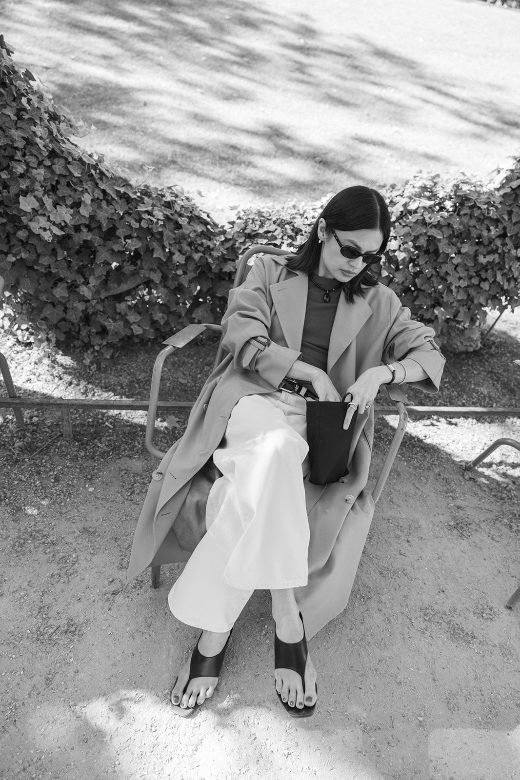 Angela Galvez, personal stylist, seated on a park chair in Paris